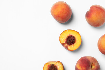 Cut and whole fresh ripe peaches on white background, flat lay. Space for text