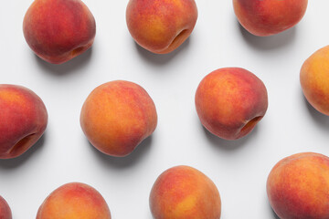 Many whole fresh ripe peaches on white background, flat lay