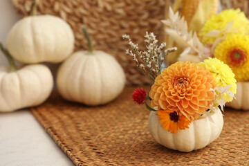 Small pumpkin with autumn bouquet on table, selective focus