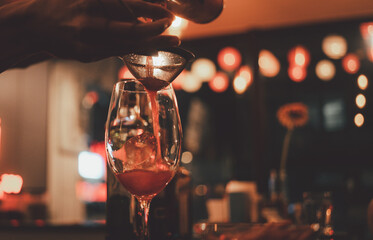 Bartender prepares a cocktail at the bar at night club