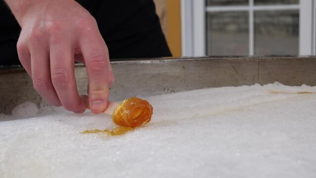 Male Rolling Maple Syrup on Snow