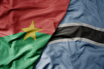 big waving national colorful flag of burkina faso and national flag of botswana .