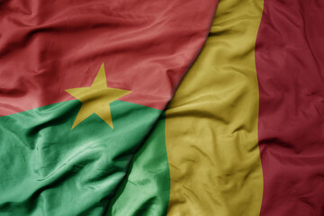 big waving national colorful flag of burkina faso and national flag of mali .