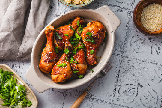 Chicken drumsticks with sesame seeds and rice, Asian cooked chicken on the table copy space