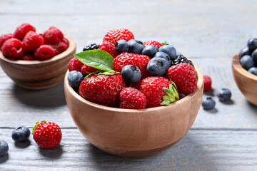 Different fresh ripe berries on light grey wooden table, closeup