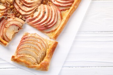 Freshly baked apple pie with nuts on white wooden table, top view. Space for text