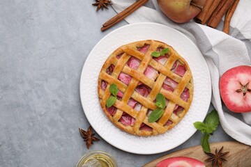Delicious apple pie with mint and ingredients on grey table, flat lay. Space for text