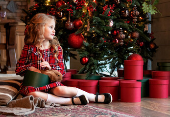 girl with a rabbit at home by the Christmas tree. Christmas concept