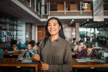 Confident high school student standing in a busy library