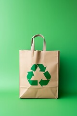 Paper bag with a recycle symbol on green background with copy space. Eco recycling concept.