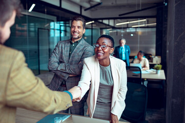 Colleagues warmly greeting each other in a lively office setting