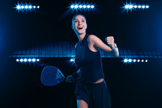 Padel tennis player with racket on tournament. Girl athlete with paddle racket on court with neon colors. Sport concept. Download a high quality photo for design of a sports app or tour events.