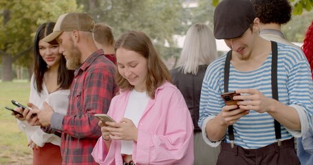 Using mobile internet. Social Gathering. Portrait friends engaging conversation, young adults talking Sharing online using phone. Bearded man talking black hair woman. 
