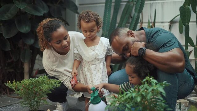 Happy African American family enjoying gardening at home