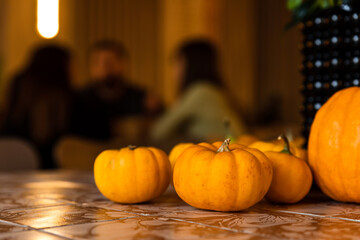 Pumpkin autumn Halloween decoration on the table in a coffee shop - 671770985