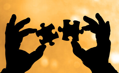 illustration. 2 jigsaw Puzzles with human hands. black silhouette of two Puzzles in male hand...