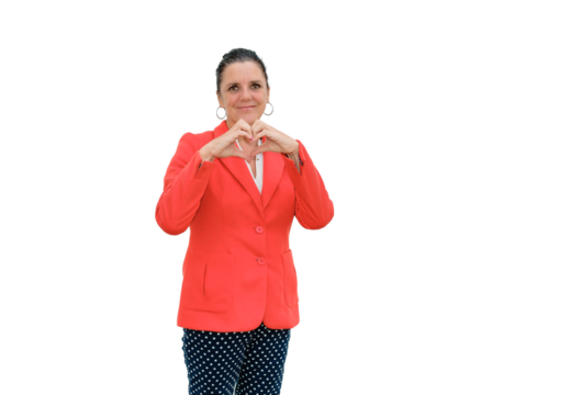 Woman standing with a heart gesture in her hands on a transparent background, wearing a red jacket and blue trousers with white polka dots.