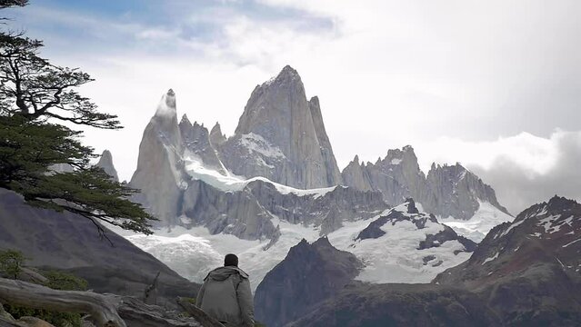 Hiker admiring the mighty of the andes and the Mount Fitz Roy, one of the hardest rocks to climb, at the National Park in El Chalt&eacute;n, in Argentinian Patagonia. Slow motion dramatic view of the park 