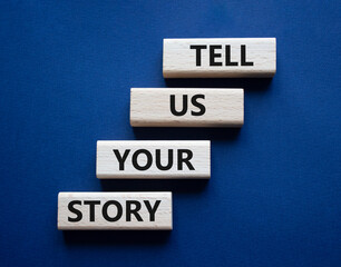 Tell us your story symbol. Concept words Tell us your story on wooden blocks. Beautiful deep blue...