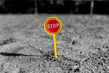 Toy road sign STOP in the middle of a sand field. Toy STOP sign on the sand. STOP road sign in a...