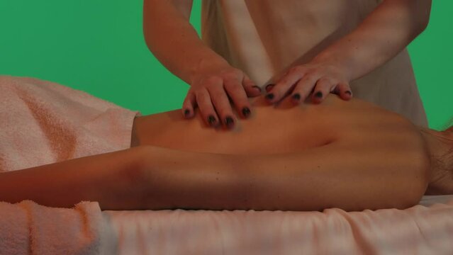 Beauty salon, woman on massage table, Chroma key green screen background, therapist doing slow relaxing back massage, close up. Advertising area, workspace mockup.