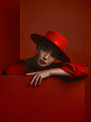 Fashion, portrait and a vintage woman on a red background for a sexy or creative aesthetic. Retro, rich and an elegant, classy or stylish model or girl with cosmetics isolated on a studio backdrop