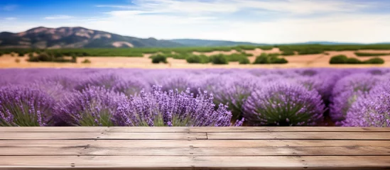 Foto op Canvas Empty rustic old wooden boards table copy space with purple lavender flowers field in background. Product display template. Generative AI © Lubo Ivanko