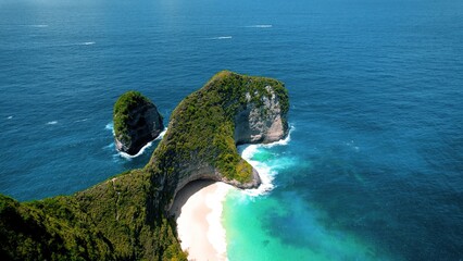 Epic mountain landscape and turquoise sea waves on tropical sandy beach. Pristine nature, dense green forest on cliff.
