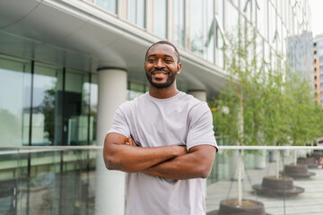Happy african american man smiling outdoor. Portrait of young happy man on street in city. Cheerful joyful handsome person guy looking at camera. Freedom happiness carefree happy people concept