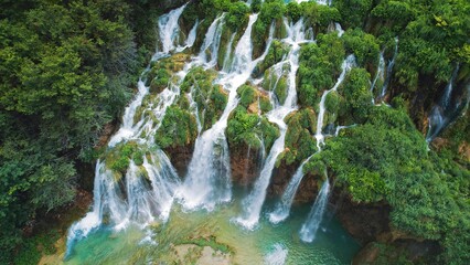 Tropical forest and mountain landscape with streams of water and waterfalls. Cascades flow among...