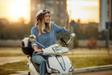 Portrait of happy woman riding on motorbike in city street