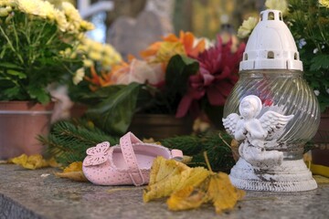 A pink shoe on a child's grave in the cemetery.