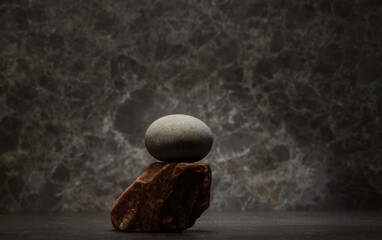 minimalist composition of natural stones for product presentation. zen stones for the podium on a dark background. cosmetology perfumery medicine skin care hygiene products concept.