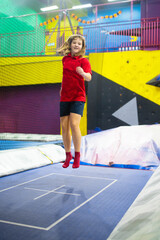 Child jumping in trampoline park. Bounce fun.