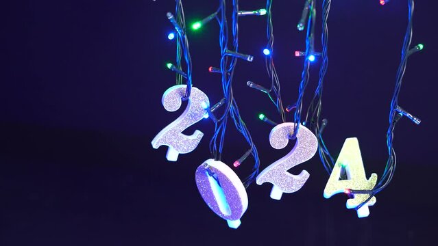 Numeri del nuovo anno appesi alle luci colorate, anno nuovo 2024