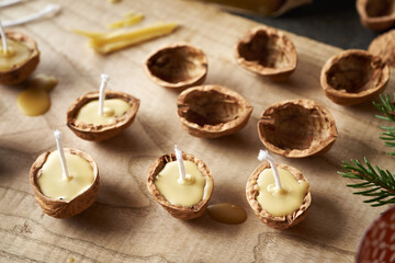 Handmade production of Christmas candles from bees wax and nut shells