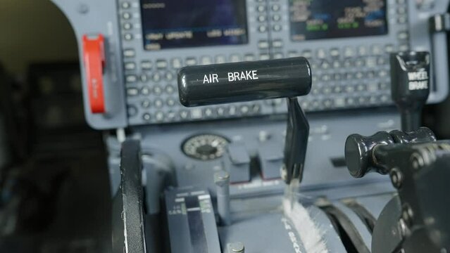 Close up shot of speed brake handle on main instrument panel in plane's cockpit. Black lever slowing down vehicle by presenting drag inducing surface to airflow when opened
