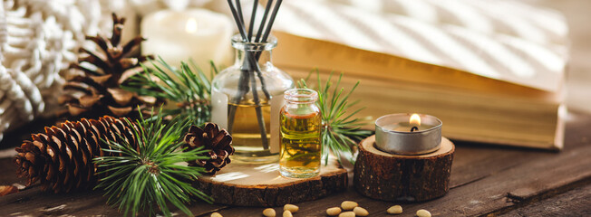 Organic essential oil, pine nuts, cedar cone on rustic wooden dark background. Concept of natural ingredients, naturopathy, herbal extracts and essence. Alternative medicine, aromatherapy banner