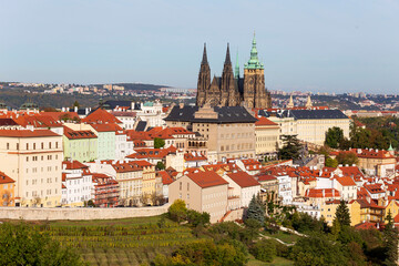 Obraz premium Autumn Prague City with gothic Castle, colorful Nature and Trees with blue Sky from the Hill Petrin, Czech Republic
