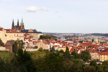 Fototapeta premium Autumn Prague City with gothic Castle, colorful Nature and Trees with blue Sky from the Hill Petrin, Czech Republic