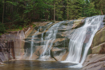 Mumlava waterfall, view from left riverside. Mountain river Mumlava, Krkonose national park, Czech Republic, summer afternoon.