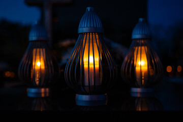 Candle light in the cemetery at night. Selective focus.All saint's day.  Lanterns in the cemetery at night.Lantern on the background of burning candles in the night.