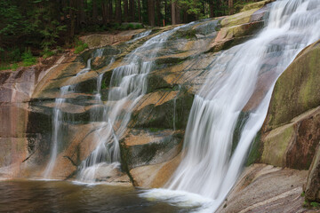 Mumlava waterfall, view from left riverside. Mountain river Mumlava, Krkonose national park, Czech Republic, summer afternoon.