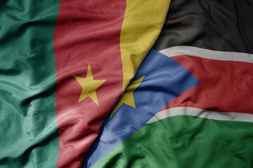 Obraz premium big waving national colorful flag of cameroon and national flag of south sudan .
