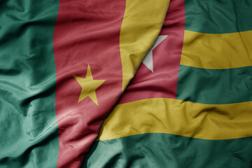 Obraz premium big waving national colorful flag of cameroon and national flag of togo .