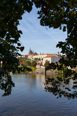 Autumn colorful Prague Lesser Town with gothic Castle above River Vltava in the sunny Day, Czech Republic