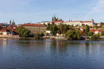 Obraz premium Autumn colorful Prague Lesser Town with gothic Castle above River Vltava in the sunny Day, Czech Republic