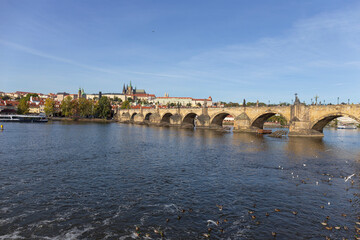 Autumn colorful Prague Lesser Town with gothic Castle above River Vltava in the sunny Day, Czech Republic