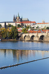 Autumn colorful Prague Lesser Town with gothic Castle above River Vltava in the sunny Day, Czech Republic