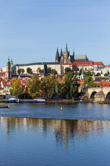 Naklejka na ściany i meble Autumn colorful Prague Lesser Town with gothic Castle above River Vltava in the sunny Day, Czech Republic